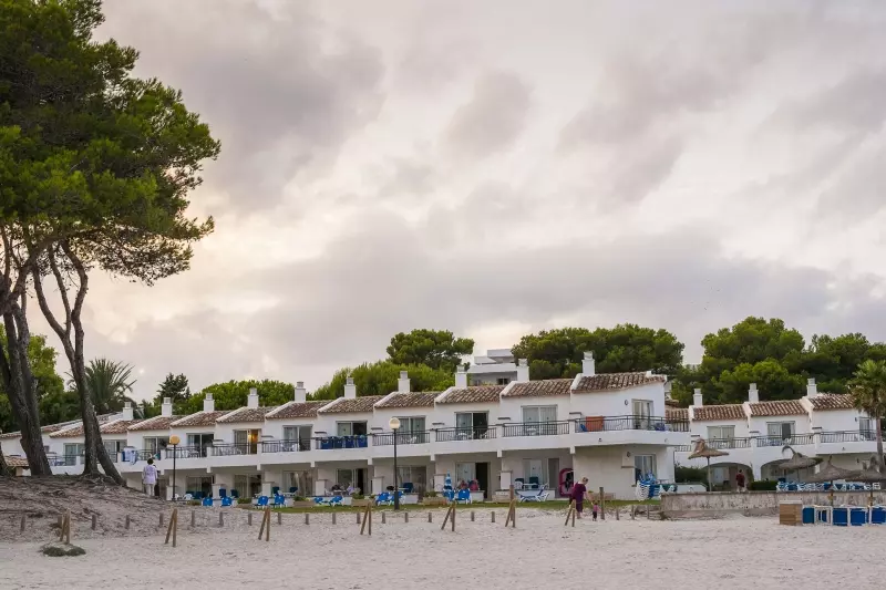 Strand und Ferienunterkunft auf Mallorca unter bewölktem Himmel