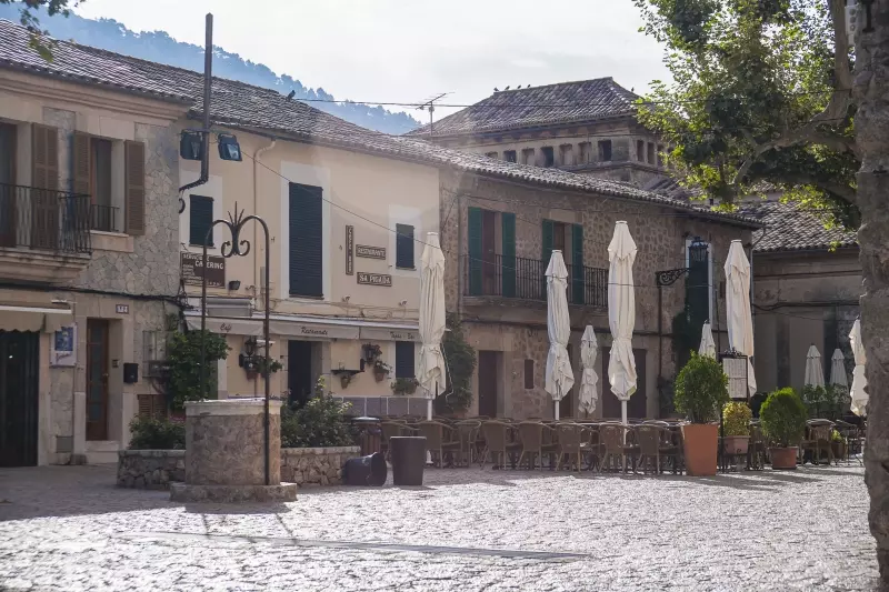 Historischer Dorfplatz in Valldemossa mit Natursteinbauten und Bergkulisse