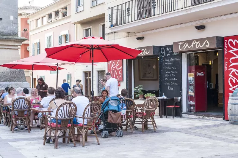 Gäste sitzen vor einem Café auf einem mallorquinischen Platz