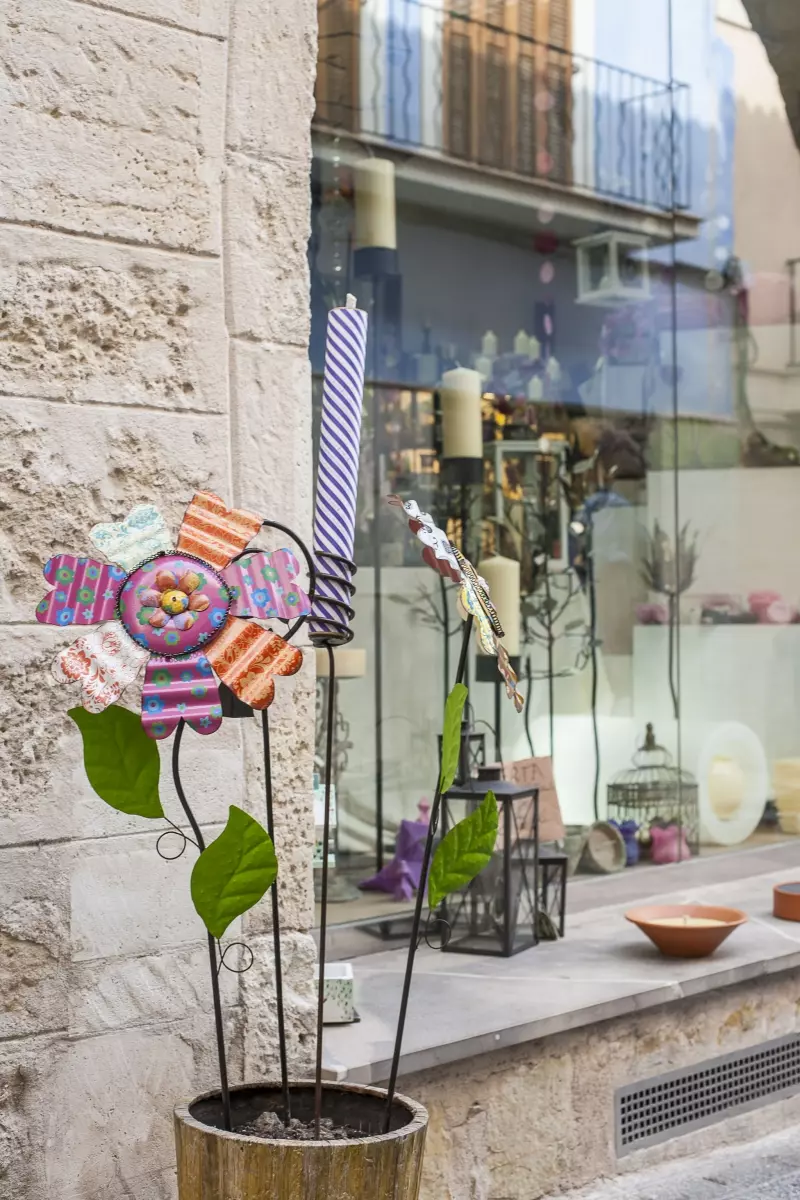 Mallorquinische Geschäftsstraße mit dekorativem Straßenmotiv und lokalen Produkten im Schaufenster