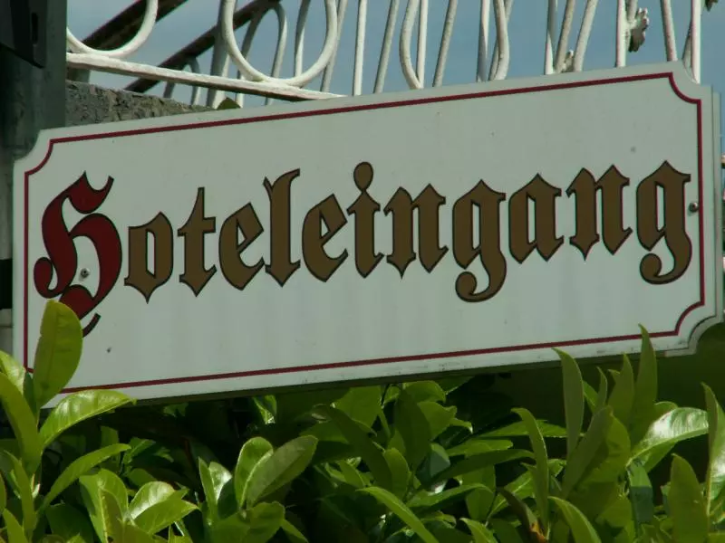 Historisches Hotelschild zwischen grünen Blättern