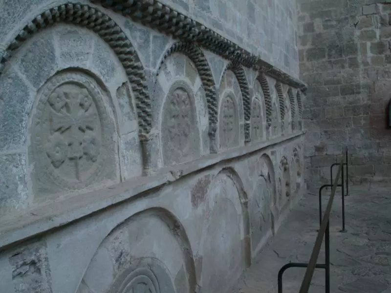 Steinernes Klosterrelief mit Rundbogen und religiösem Ornament