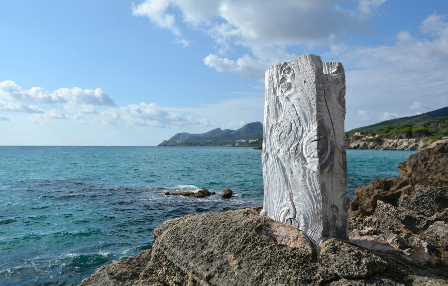 Verwitterter Holzpfosten auf den Felsen zwischen dem Hafen von Cala Ratjada und dem Strand von Son Moll