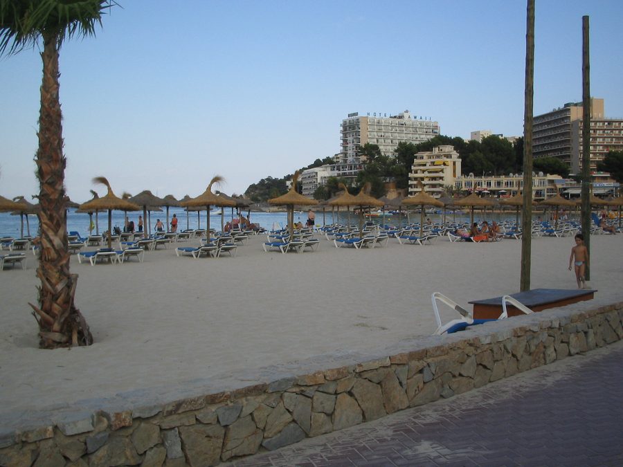 Playa de Palmanova mit Sandstrand und bebauter Uferpromenade in Calvià auf Mallorca